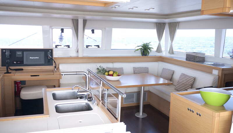 Interior view of the kitchen and the saloon of the catamaran Lagoon 450