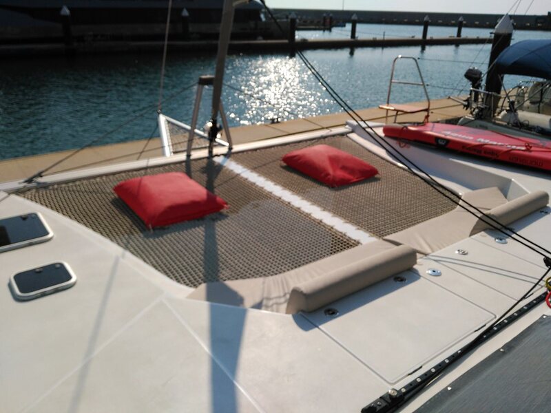 Solarium-net in the front of the sailing catamaran for rent in Barcelona