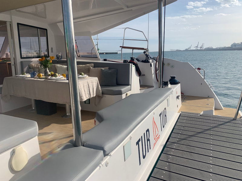 A terrace for jumping into the water in the back of the catamaran for rent in Barcelona