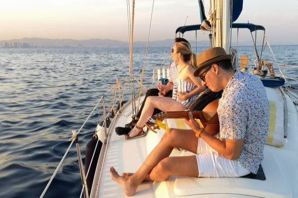 Playing the guitar on the boat at sunset in Barcelona